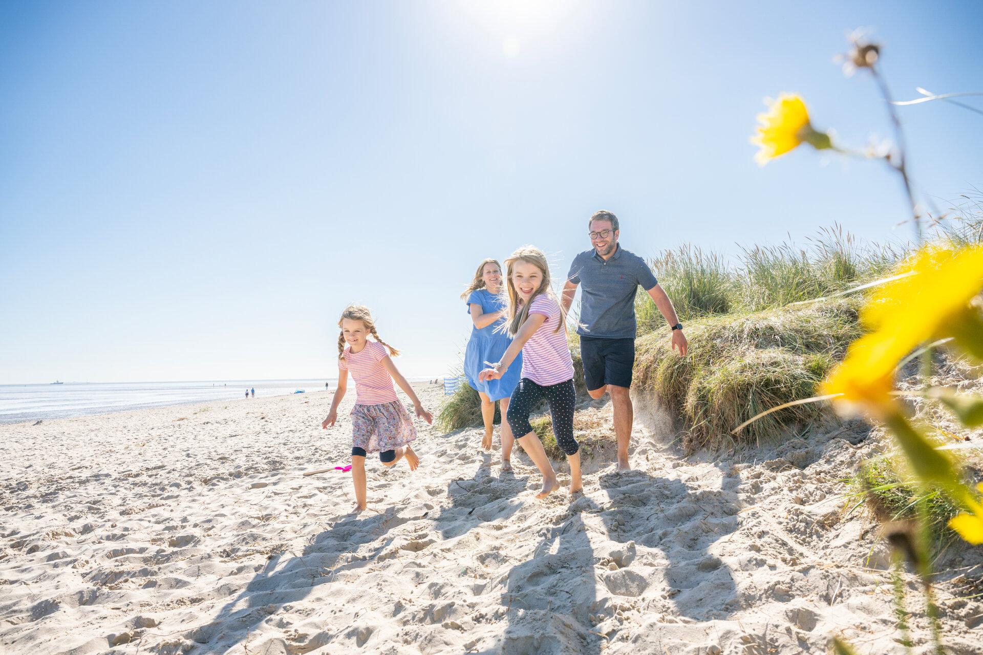Familie spielt am Strand in Schillig im Wangerland